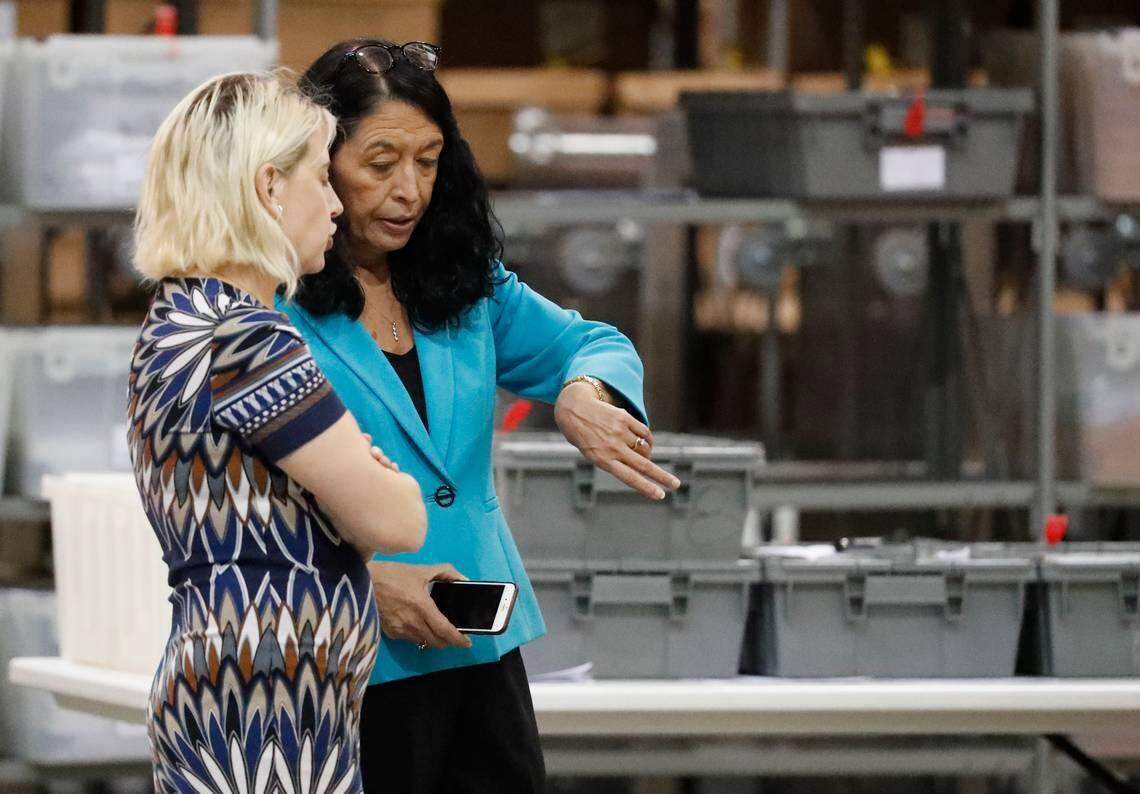 Palm Beach County Supervisor of Elections Susan Bucher checks her watch as she talks to an employee at the elections office during a machine recount on Thursday, Nov. 15, 2018, in West Palm Beach, Fla.