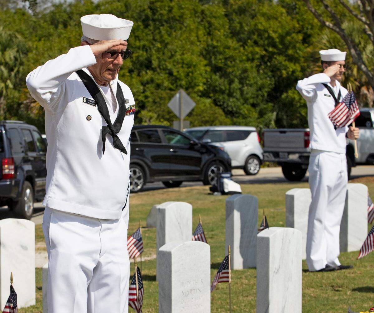 Retired Navy and U.S. Naval Sea Cadet Corps leader Joe Jiampetti and U.S. Naval Sea Cadet Corps Carlo Fulgenzi honor veterans after placing American flags at the South Florida National Cemetery Sunday, May 30, 2021 in Lake Worth, Florida.