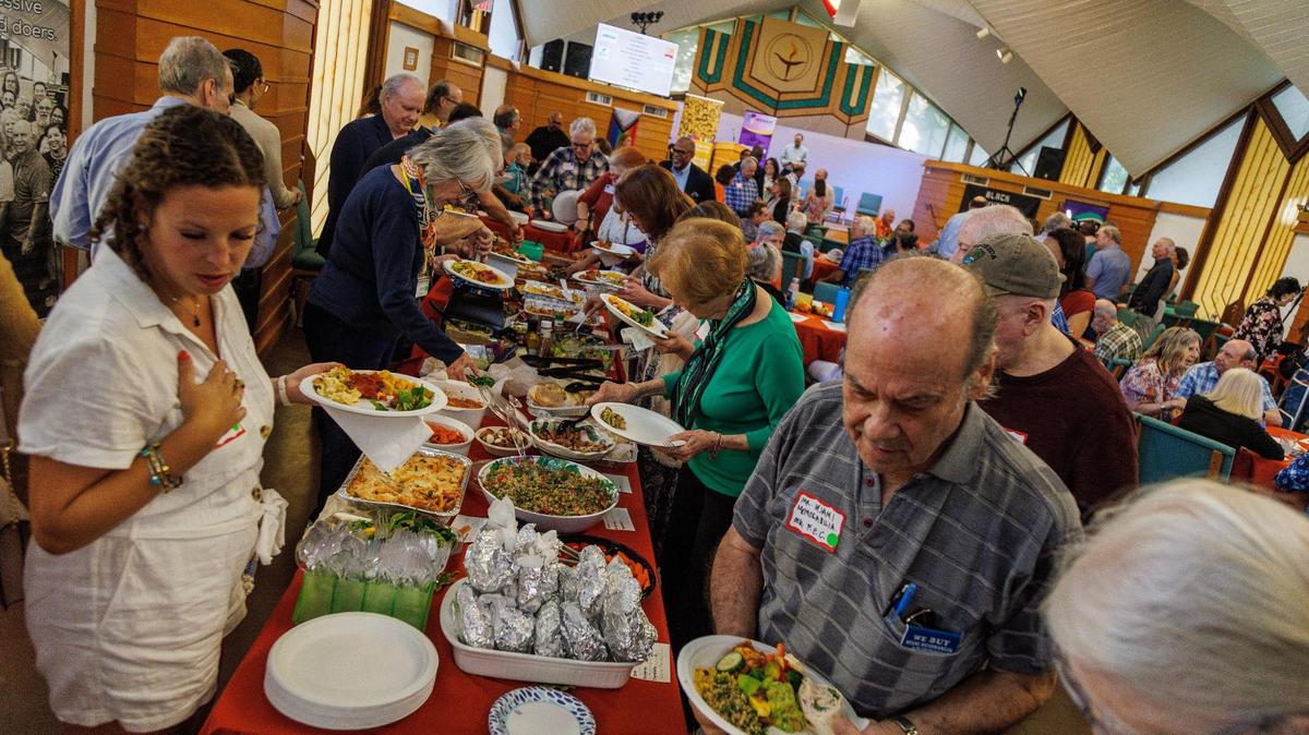Attendees serve some food during an Interfaith Potluck dinner Sunday, Oct. 22, 2023, at the Unitarian Universalist Congregation of Miami. The dinner was organized by Temple Beth Am’s unBIASed Initiative, Mosaic Miami and the Unitarian Universalist Congregation of Miami to combat hate, antisemitism amid the Israel-Hamas war.