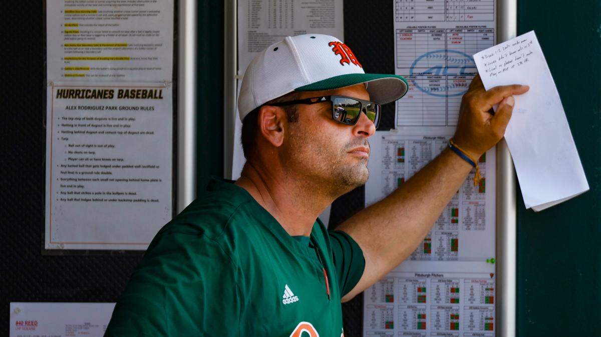Miami Hurricanes head coach J.D. Arteaga stands in the dug out as he keeps an eye on the game against Pittsburgh Panthers at Alex Rodriguez Park at Mark Light Field on Coral Gables, Florida on Saturday, May 18, 2024.