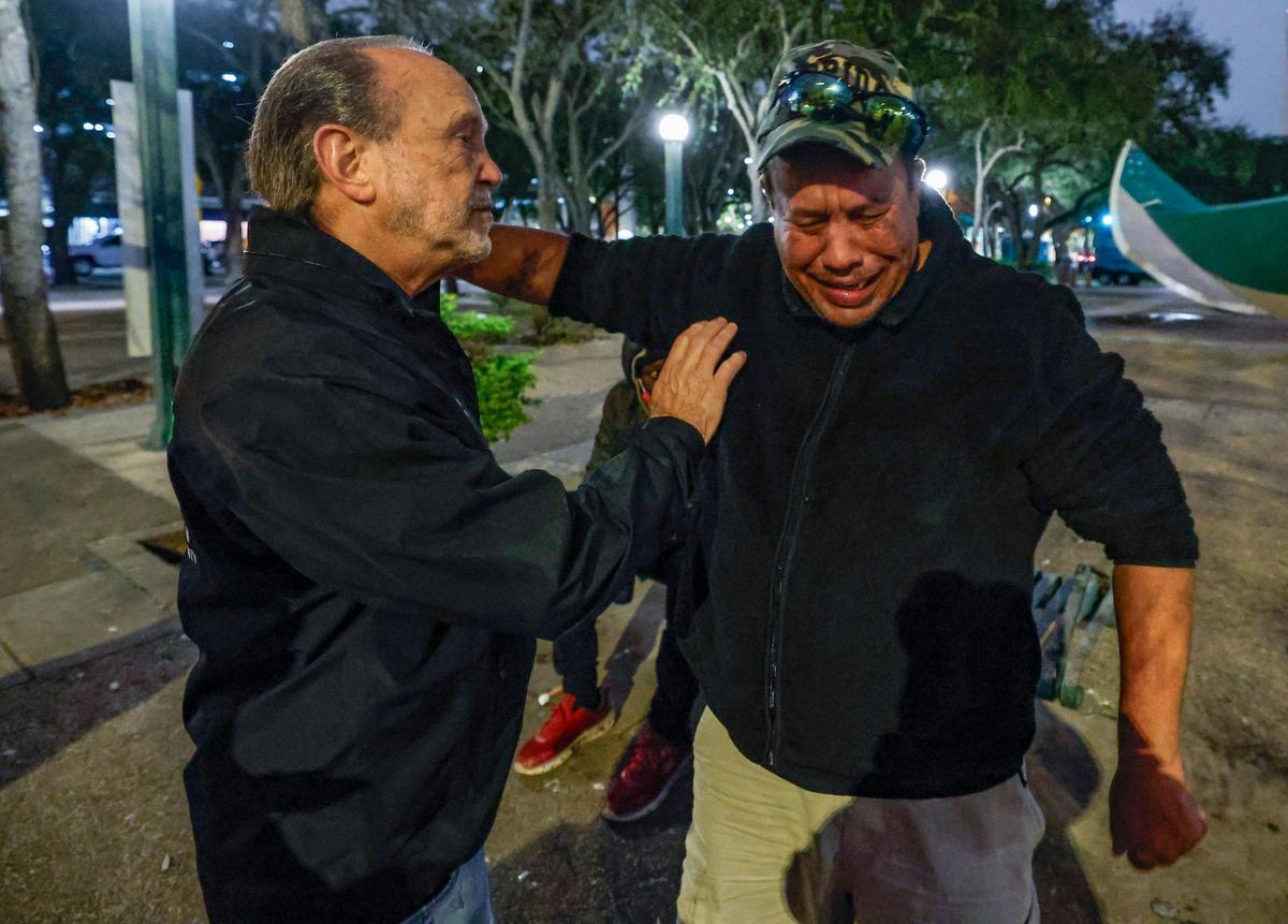 Roberto Garcia reacts after receiving support from Ron Book, the chair of the Miami-Dade Homeless Trust, on a cold winter night during the Homeless Trust’s biannual Homeless Census in Miami on Thursday, Jan. 23, 2025.