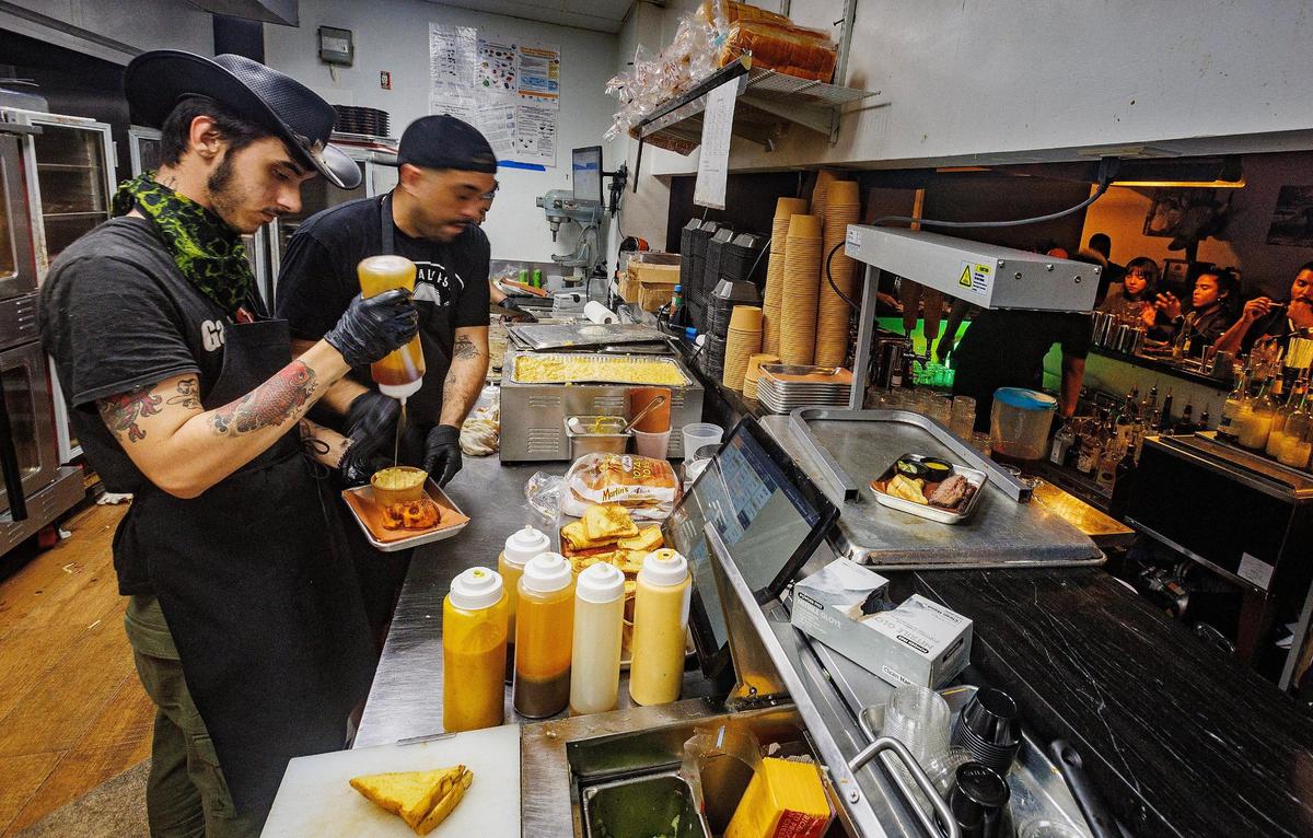 Line cooks Bryan Rodriguez Garcia (left) and Jose Acevedo prepare some orders in the kitchen of Apocalypse BBQ in Kendall.
