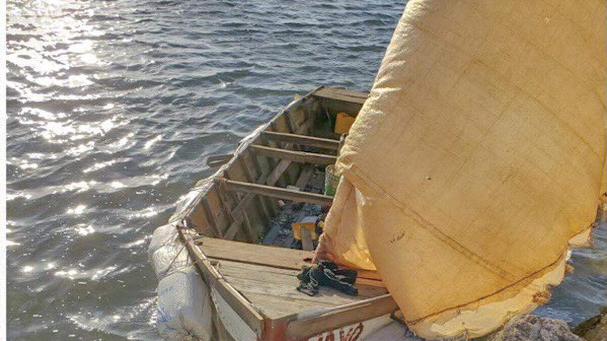 A wooden sailboat rests on the rocks of a Tavernier beach in the Florida Keys Friday, Aug. 27, 2021. Fourteen people from Cuba arrived on the vessel.