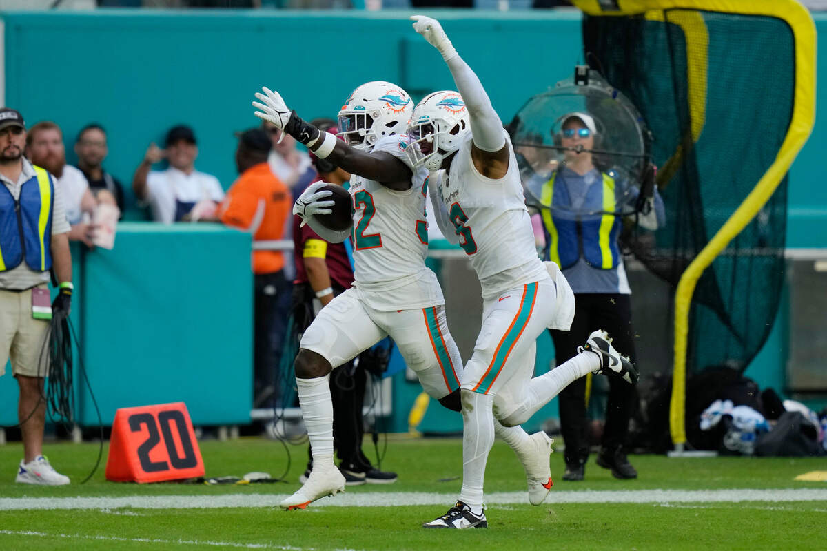 Miami Dolphins safety Verone McKinley III (32) runs with safety Jevon Holland (8) after intercepting a pass during the second half of an NFL football game against the Houston Texans, Sunday, Nov. 27, 2022, in Miami Gardens, Fla. (AP Photo/Lynne Sladky)