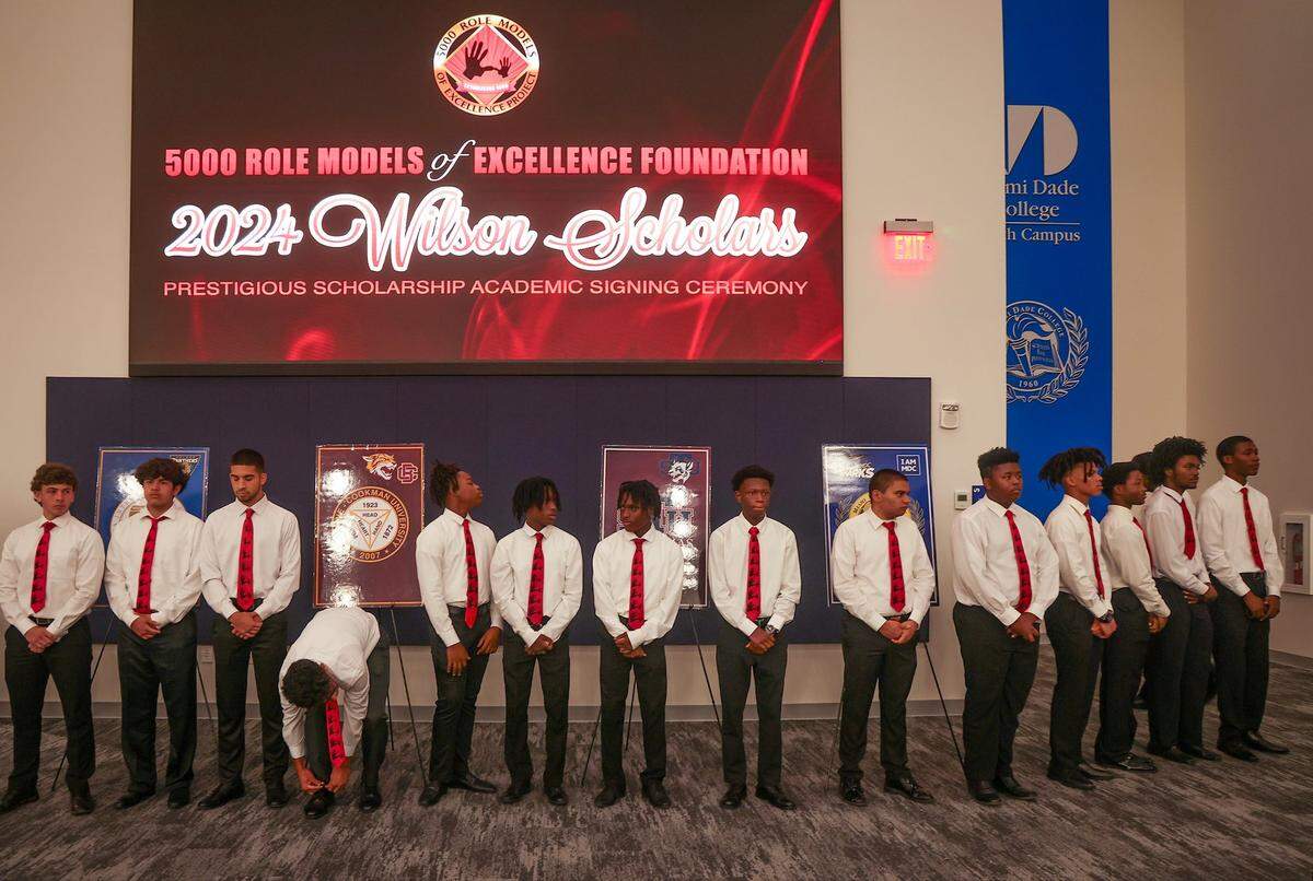 One member of the 2025 Class of Wilson Scholars, ties his shoe as they wait to greet attendees of the signing ceremony during the Wilson Scholars Academic Signing Ceremony of the 5000 Role Models of Excellence Project that connected Wilson Scholars from public high schools in Miami to full scholarship support to prestigious colleges and universities during its ceremony held at the Miami Dade College-North Campus SOJ Multipurpose Room on Sunday, June 9, 2024 in Miami, Florida.