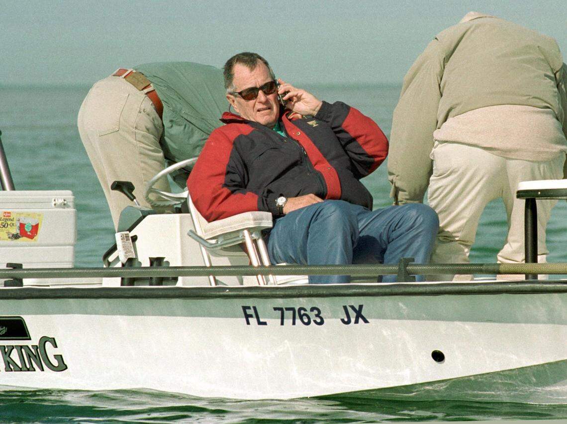Former President George Bush speaks on a cellular phone just after finishing the first day of angling at the George Bush/Cheeca Lodge Bonefish Tournament on Tuesday, Nov. 28, 2000, in the Florida Keys, near Islamorada, Fla. The event, which concludes Wednesday, will raise funds for The Nature Conservancy and Bush’s presidential library. (AP Photo/Andy Newman)