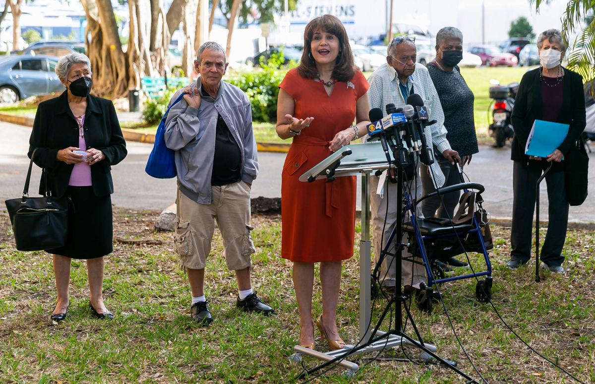 La senadora de Florida Annette Taddeo, en el centro, habla sobre los reclamos de cambios en la afiliación de votantes durante una conferencia de prensa fuera de Haley SOFGE Towers en el vecindario Little Havana de Miami el viernes 11 de febrero de 2022. A Taddeo se unieron algunos de los residentes de Haley SOFGE. Towers que dicen que sus afiliaciones a partidos políticos fueron cambiadas sin su consentimiento.
