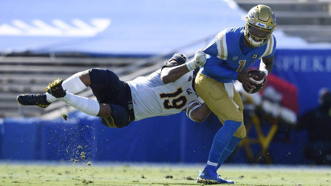 UCLA quarterback Dorian Thompson-Robinson, right, avoids a tackle by California linebacker Cameron Goode during the first half of an NCAA college football game in Los Angeles, Sunday, Nov. 15, 2020.