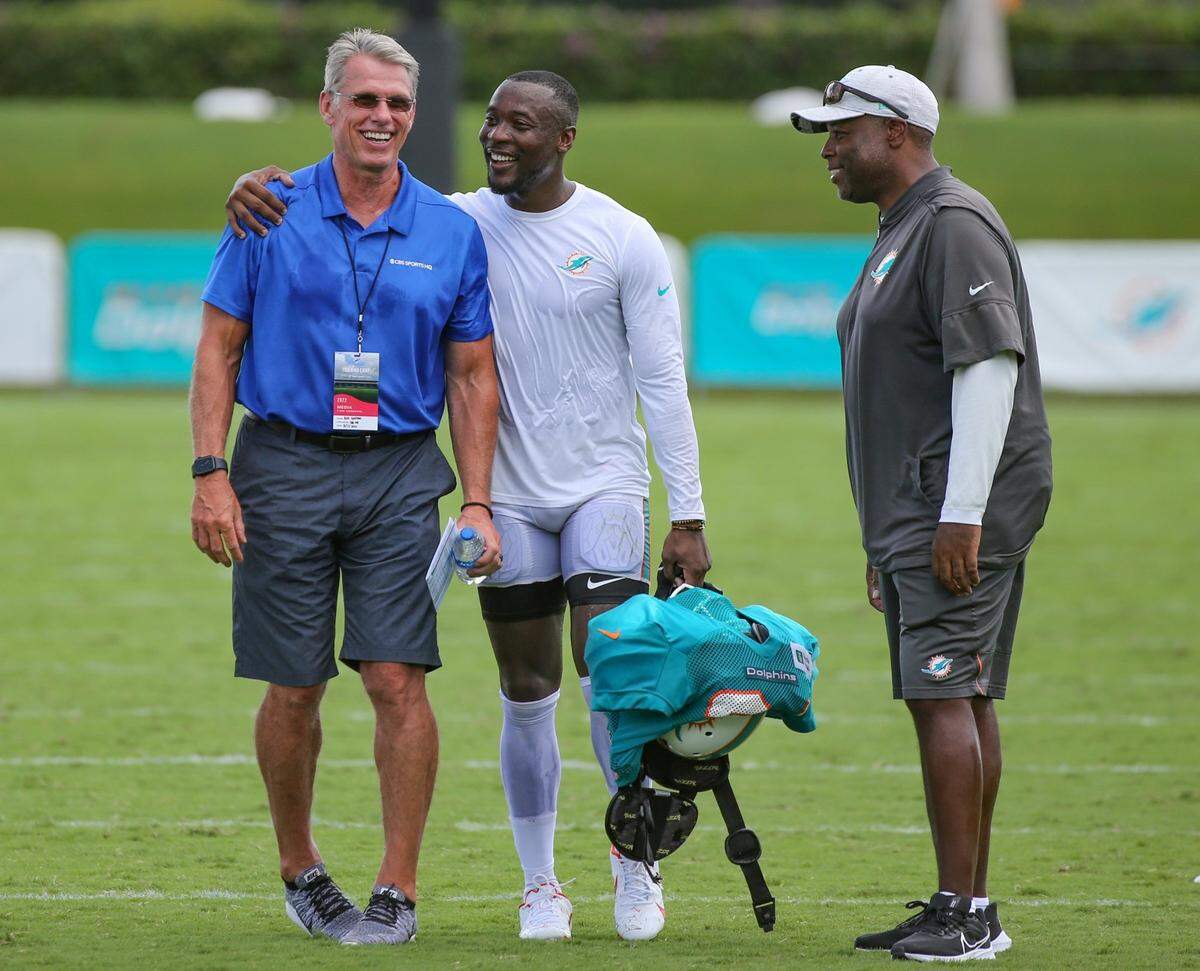 Miami Dolphins Mackensie Alexander (34) walks with former general manager of the Miami Dolphins Rick Spielman as Miami Dolphins general manager Chris Grier looks on after practice at Baptist Health Training Complex in Miami Gardens on Wednesday, August 17, 2022.