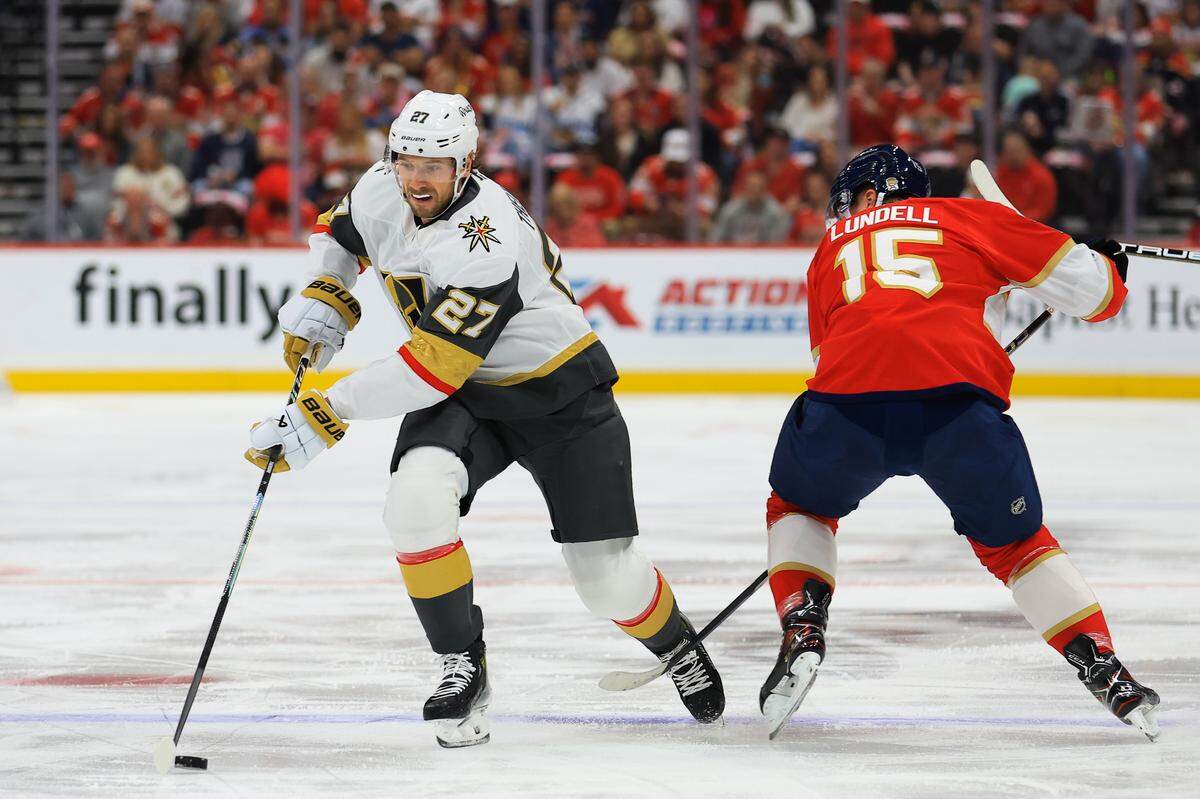 SUNRISE, FLORIDA - OCTOBER 25: Shea Theodore #27 of the Vegas Golden Knights skates the puck past Anton Lundell #15 of the Florida Panthers during the first period of the game at Amerant Bank Arena on October 25, 2025 in Sunrise, Florida. (Photo by Megan Briggs/Getty Images)