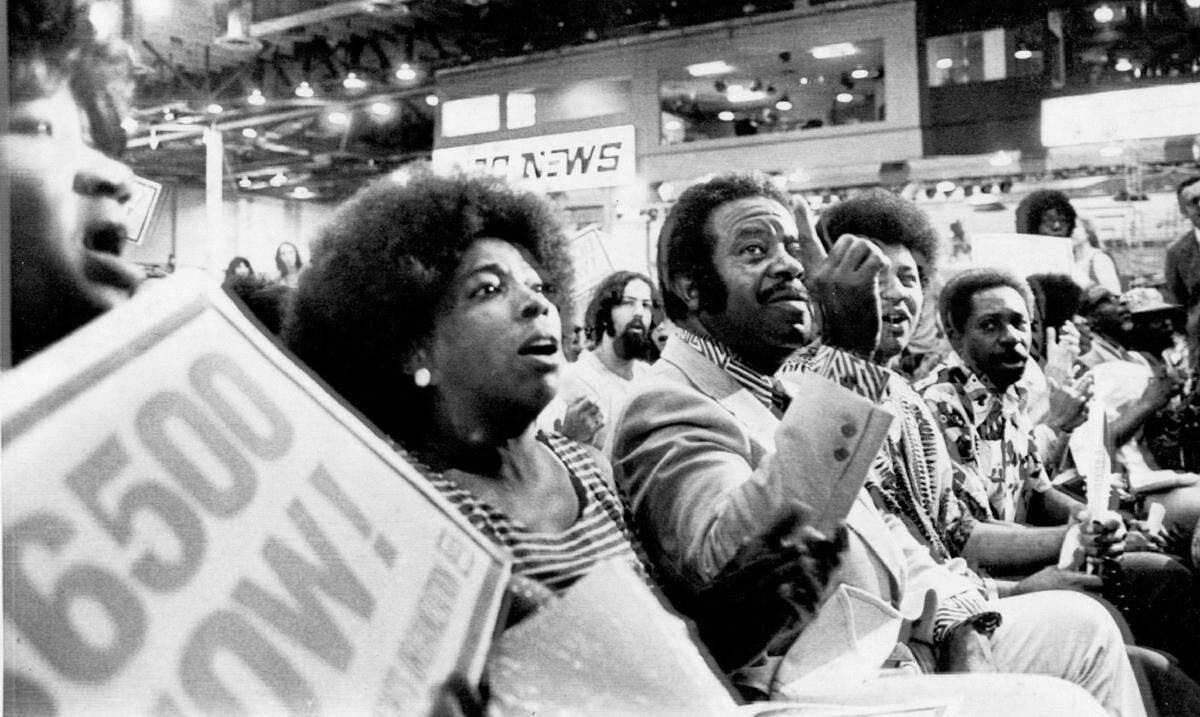 The Rev. Ralph David Abernathy gestures as he leads his National Welfare Rights Organization to the front row seats in the convention hall in Beach at the Democratic National Convention in 1972.