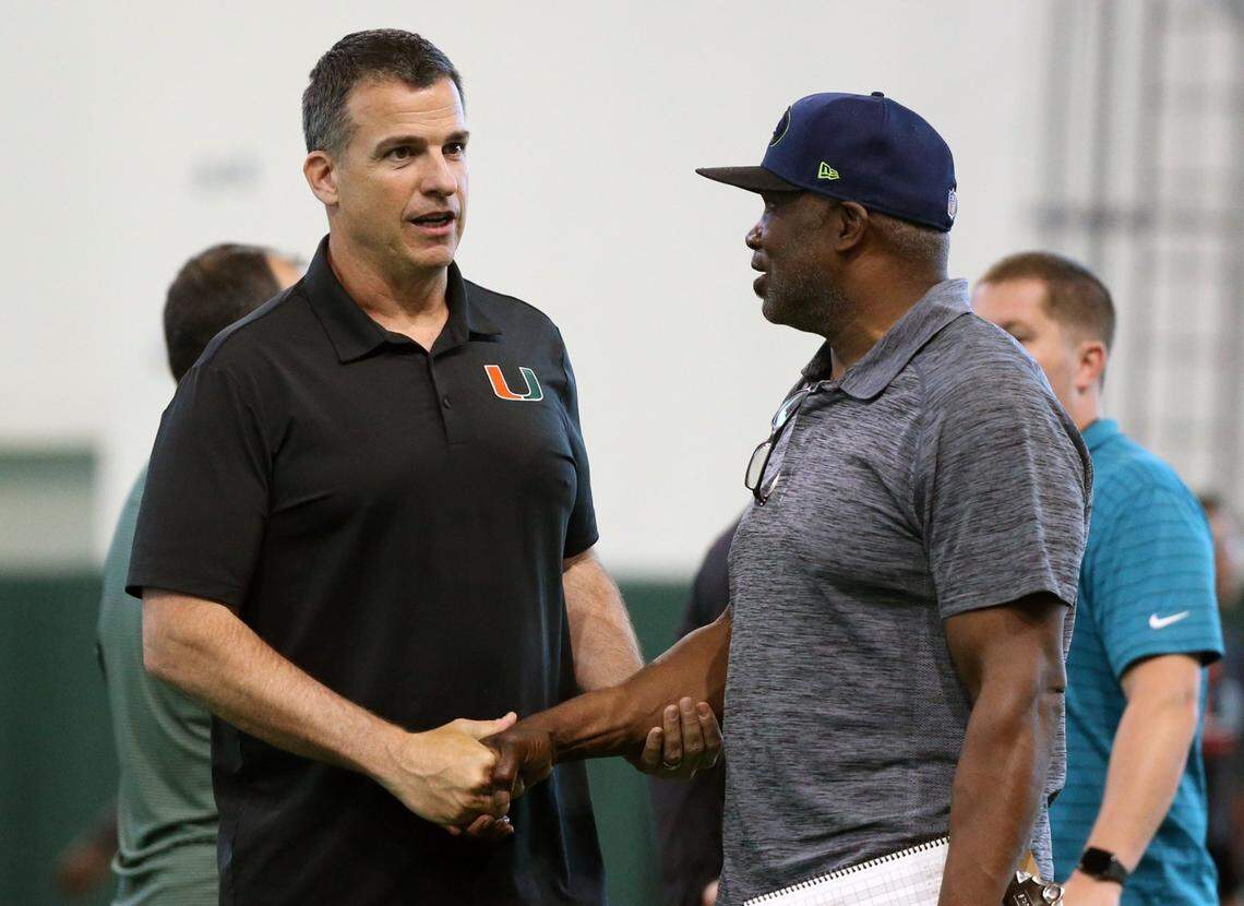 Miami Hurricanes football coach Mario Cristobal talks with former Cane player Alonzo Highsmith as graduating seniors perform for scouts at Pro Day at the University of Miami’s Carol Soffer Indoor Practice Facility in Coral Gables on March 30, 2022, ahead of the 2022 NFL Draft.
