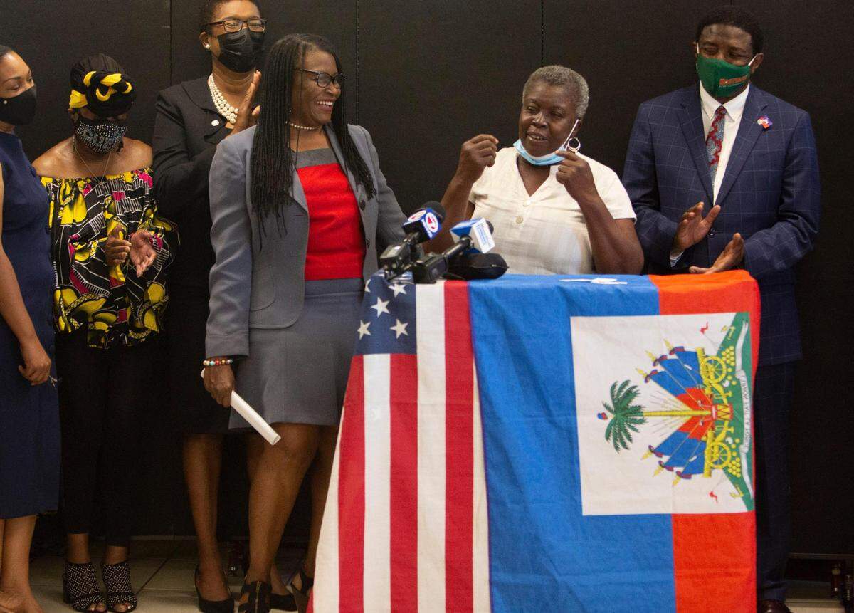 The Family Action Network Movement (FANM) held a press conference at its office in Little Haiti Monday, May 24, 2021, to applaud the Biden administration’s redesignation of TPS for Haitians. FANM’s executive director, Marleine Bastien, smiles as she listens to TPS holder Nut Luce Janvier share her story of how the redesignation impacts her family, as Dale Holness, commissioner of Broward County District 9, applauds.