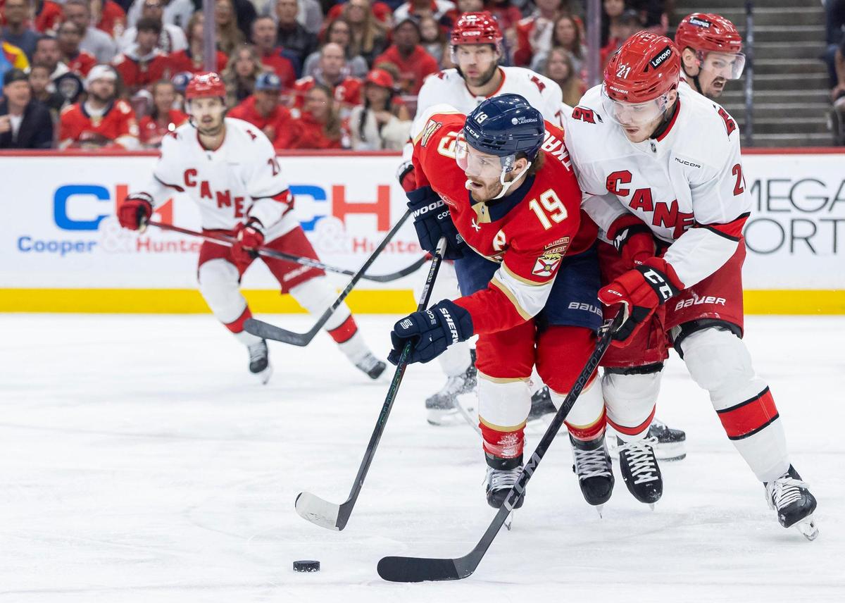 Florida Panthers left wing Matthew Tkachuk (19) looks to pass the puck as Carolina Hurricanes defenseman Alexander Nikishin (21) defends in the first period of Game 3 during the Eastern Conference final of the NHL Stanley Cup playoffs at Amerant Bank Arena on Saturday, May 24, 2025, in Sunrise, Fla.