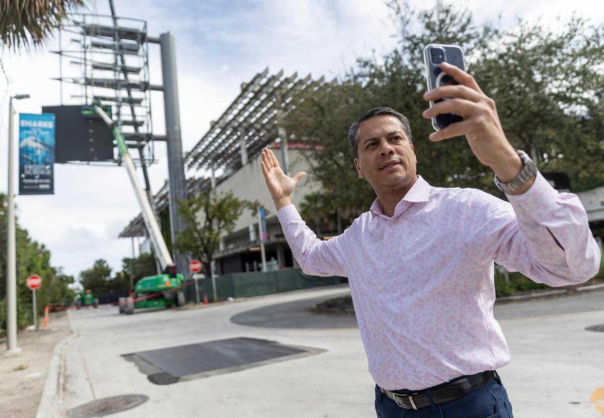 James Torres, de 52 años, presidente de Downtown Neighbors Alliance, graba un video de una valla publicitaria que se está construyendo junto al Pérez Art Museum Miami, el viernes 26 de enero de 2024, en el downtown de Miami, Florida. Torres y Miami ADN se oponen a la construcción de la valla publicitaria LED de 10 pisos, que tendrá paneles brillantes orientados hacia el tráfico entrante que circula por el Viaducto MacArthur desde el este y el oeste.