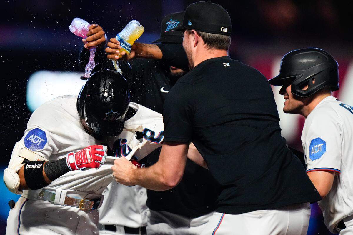 Miami Marlins second baseman Luis Arraez (3) celebrates with teammates after hitting a walk-off single against the Colorado Rockies during the tenth inning at loanDepot Park on Sunday, July 23, 2023.