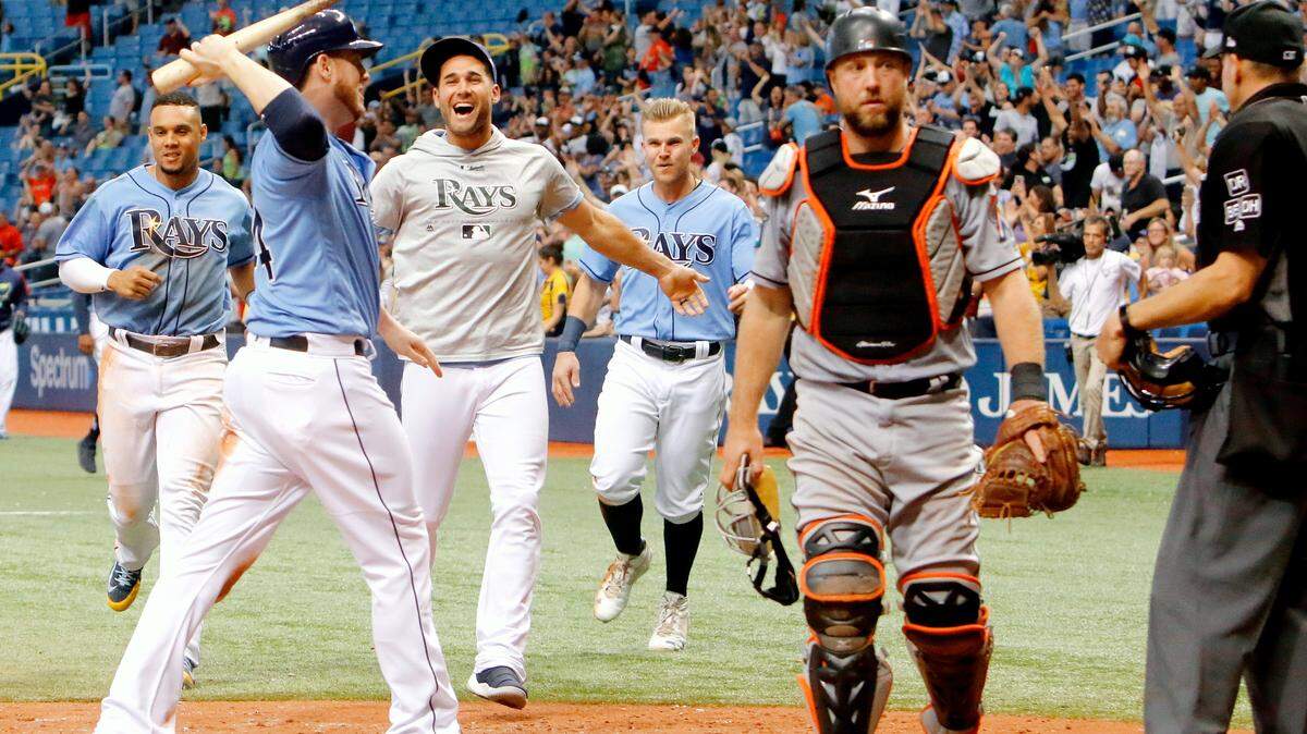 ST. PETERSBURG, FL  JULY 22: C.J. Cron #44 of the Tampa Bay Rays begins to celebrate with teammates at home plate after Daniel Robertson #28 hits a grand slam in the bottom of the ninth inning to give his team a win against the Miami Marlins at Tropicana Field on July 22, 2018 in St. Petersburg, Florida. (Photo by Joseph Garnett Jr./Getty Images)