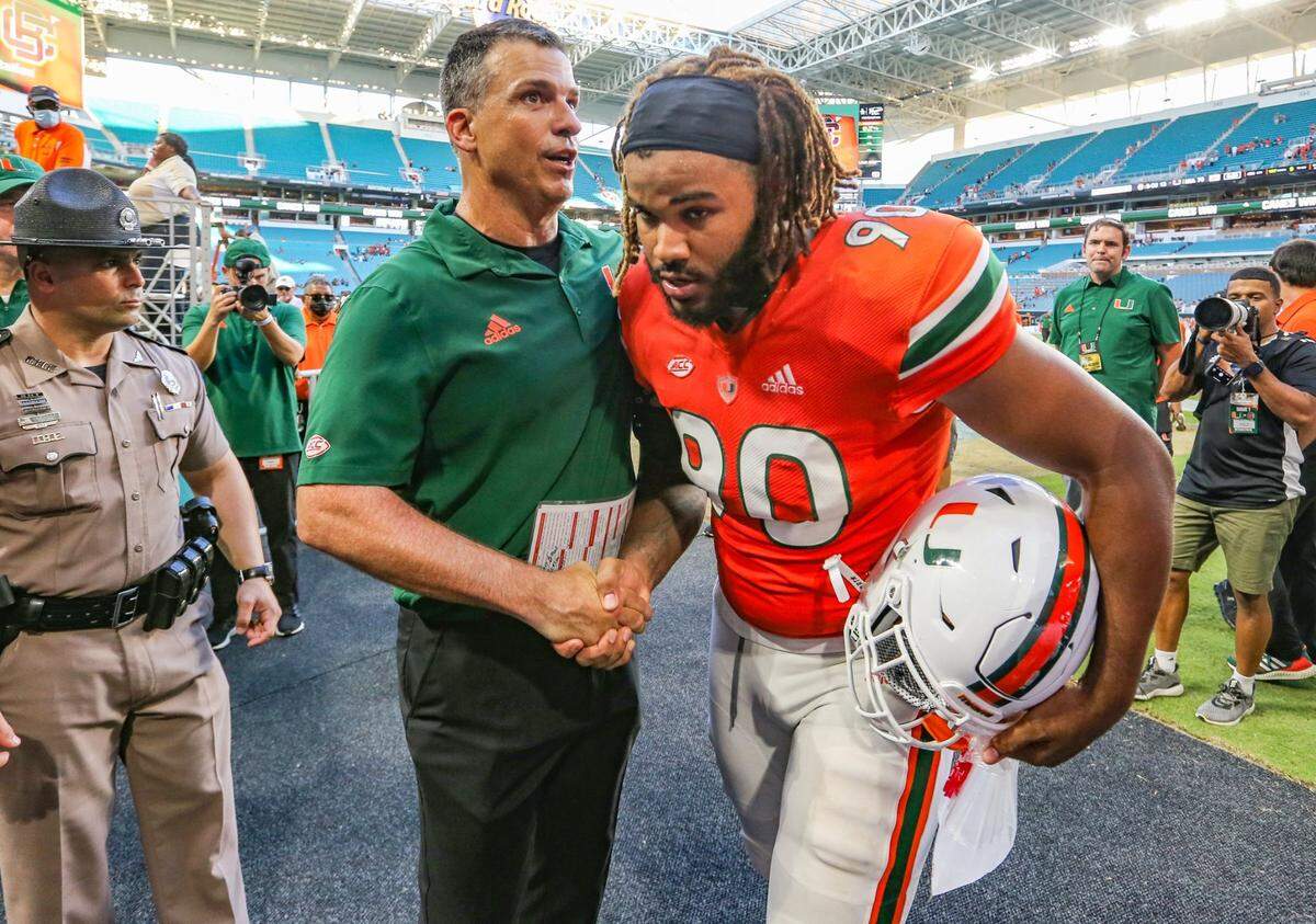 Miami Hurricanes head coach Mario Cristobal congratulates defensive lineman Akheem Mesidor (90) after the Canes defeat Bethune Cookman Wildcats at Hard Rock Stadium in Miami Gardens on Saturday, September 3, 2022.
