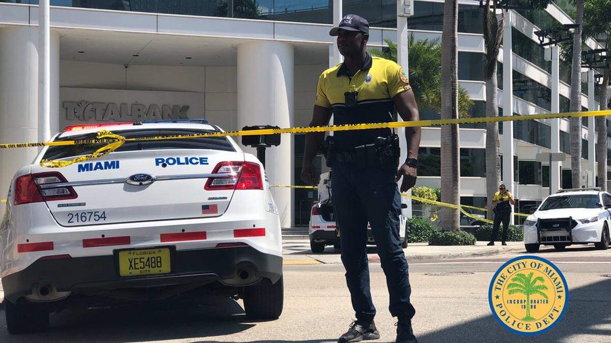 Police investigate a robbery and shooting in downtown Miami on Tuesday.