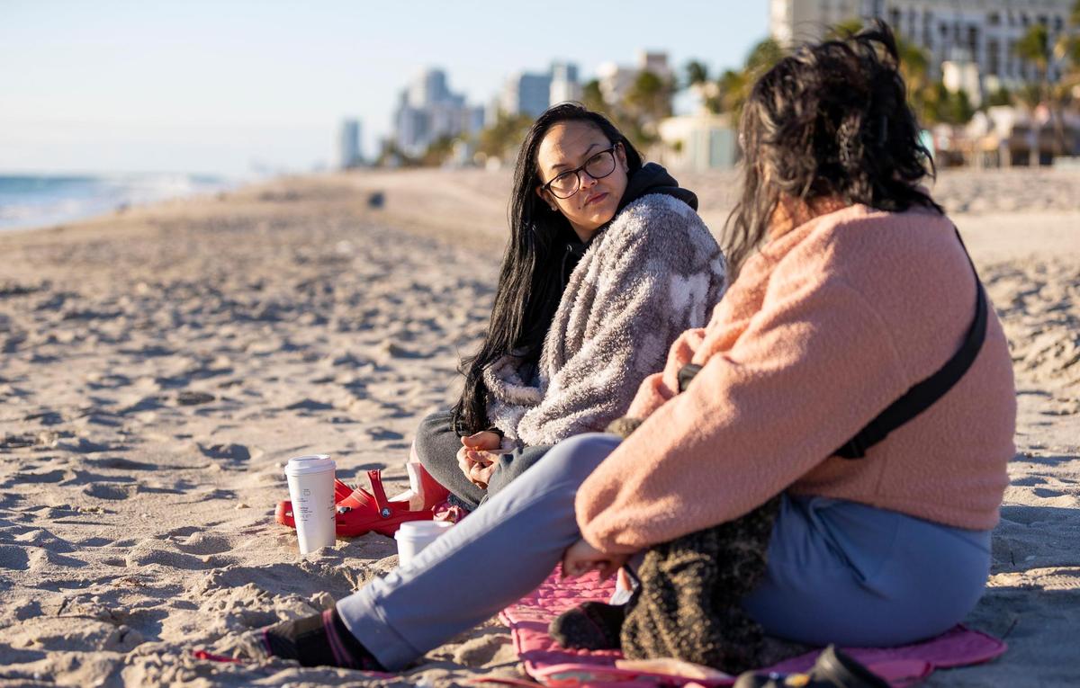 Jovanah Oliva, left, and Lizzie Lopez visit the beach as temperatures dip into the mid-40s on Saturday, Jan. 14, 2023, in Hollywood, Florida.