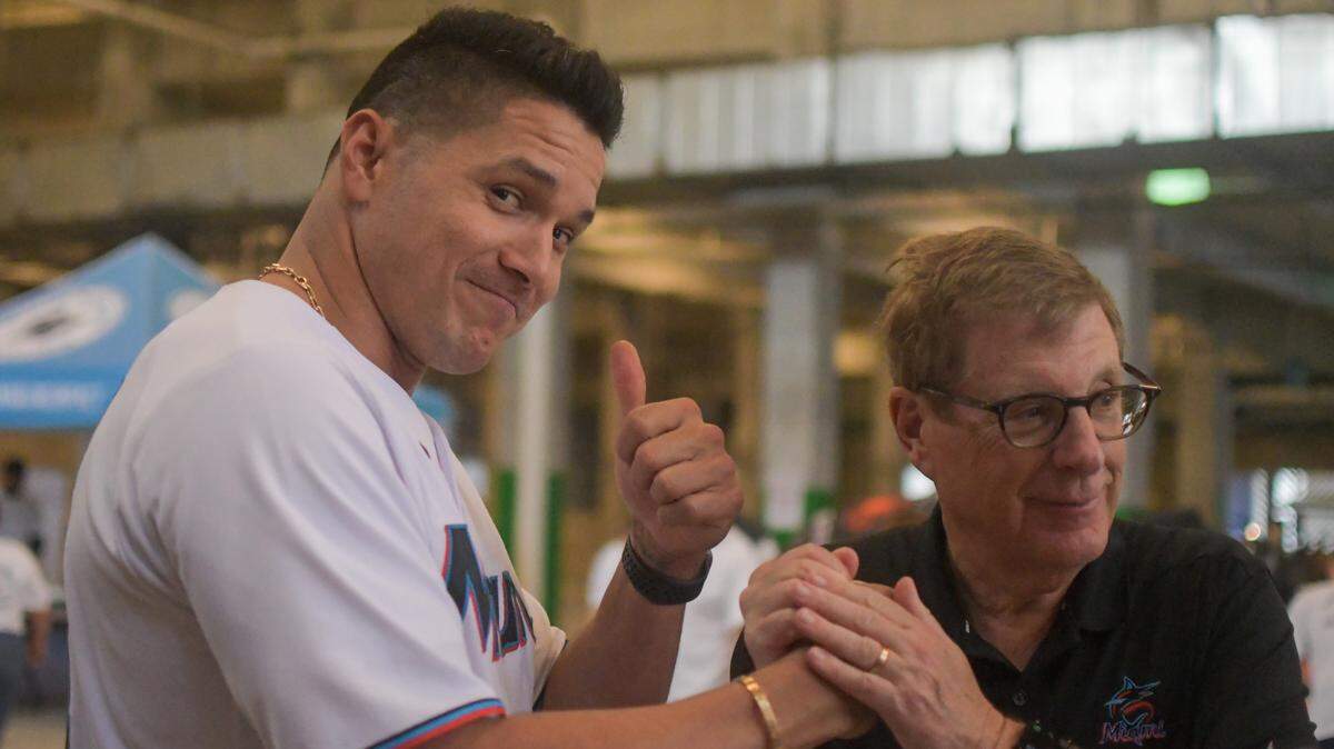 Miami Marlins outfielder Avisail Garcia, left, shakes hands with Marlins chairman and principal owner Bruce Sherman at the team’s Thanksgiving food distribution on Thursday, Nov. 17, 2022.