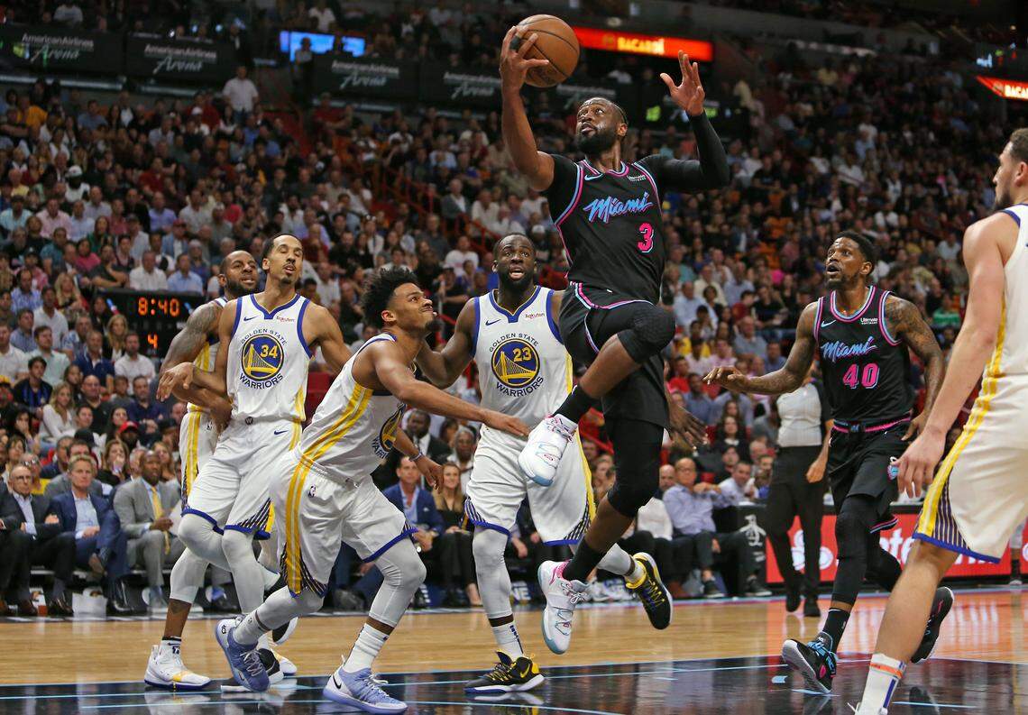 Miami Heat guard Dwyane Wade (3) goes to the basket against Golden State Warriors players Andre Iguodala (9) Shaun Livingston (34) Quinn Cook (4) Draymond Green (23) and Klay Thompson (11) in the fourth quarter of an NBA basketball game at AmericanAirlines Arena on Wednesday, February 27, 2019 in Miami.