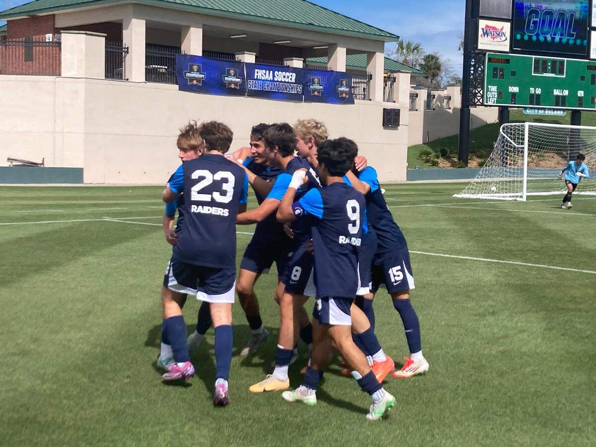 Gulliver’s Jorge Gouvea is surrounded by celebrating teammates following a second half goal that put the Raiders up 2-1 in Tuesday’s Class 3A state boys’ soccer semifinal against Delray American Heritage at Spec Martin Stadium in DeLand, Fla.