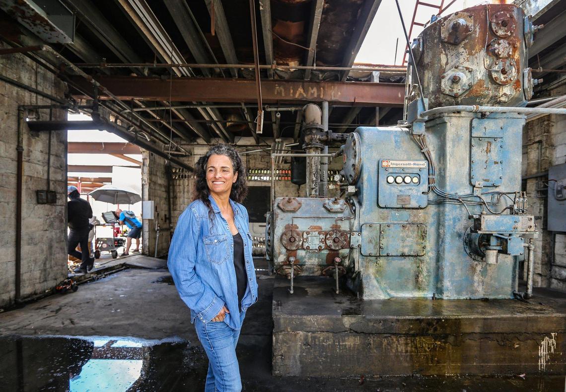 Miami developer Avra Jain stands in front of the compressor that once powered this former east Hialeah mattress factory’s conveyor system. It will be the centerpiece of a new bar at the Factory Town entertainment venue.