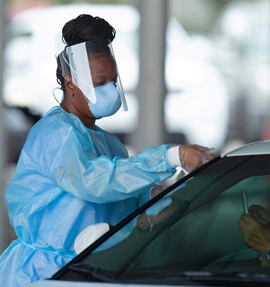 A healthcare worker instructs a person how to use a swab to test for coronavirus at the testing center located in the Miami-Dade County Auditorium in July. At the time, the county was experiencing its first rebound in COVID cases after the coronavirus crisis began in March. Now county leaders worry a second surge has begun, with a peaking coming in late November.