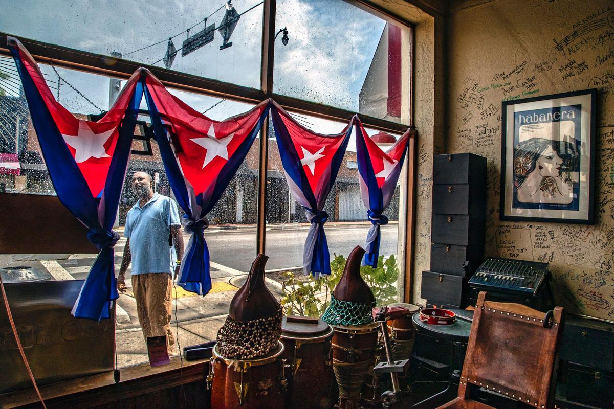 Top Cigars owner Crist Mena stands outside his Cigar Club as he looks forward to customers returning as non-essential businesses are allowed to open along Calle Ocho in Little Havana on Tuesday, May 19, 2020.