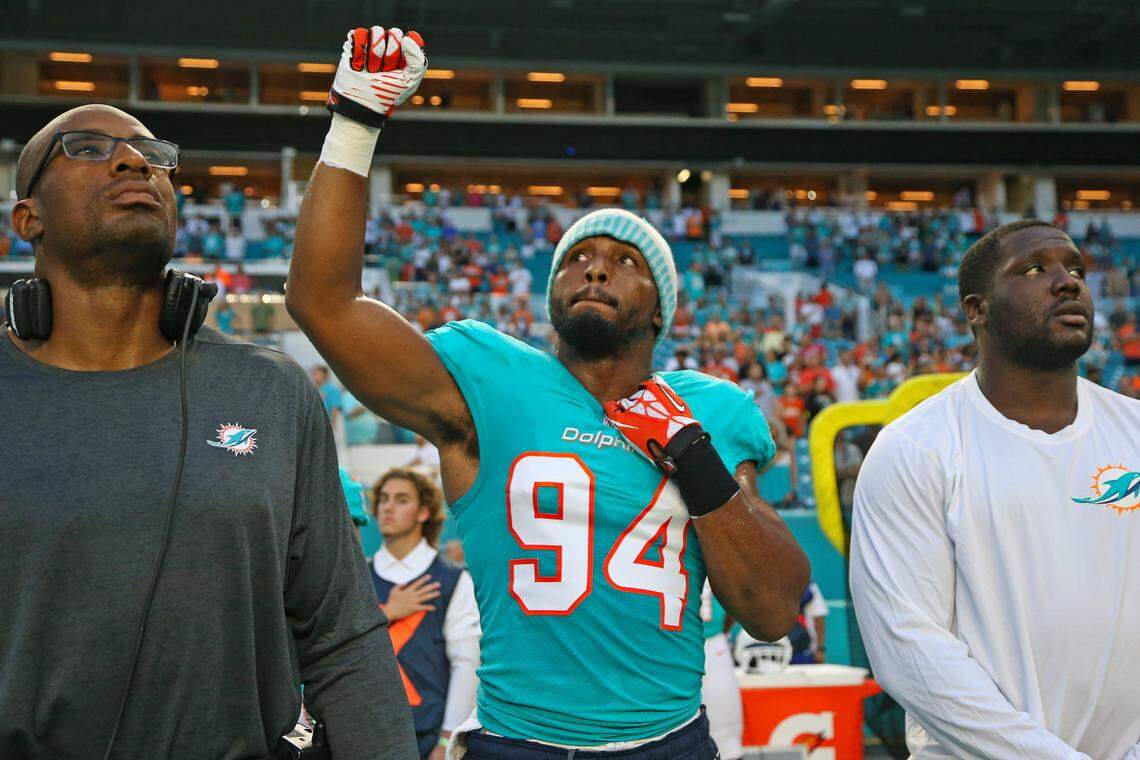Miami Dolphins defensive end Robert Quinn #94 fist pump while listening to the national anthem before the start of an NFL football game  against the Tampa Bay Buccaneers at Hard Rock Stadium on Thursday, August. 9, 2018, in Miami Gardens.