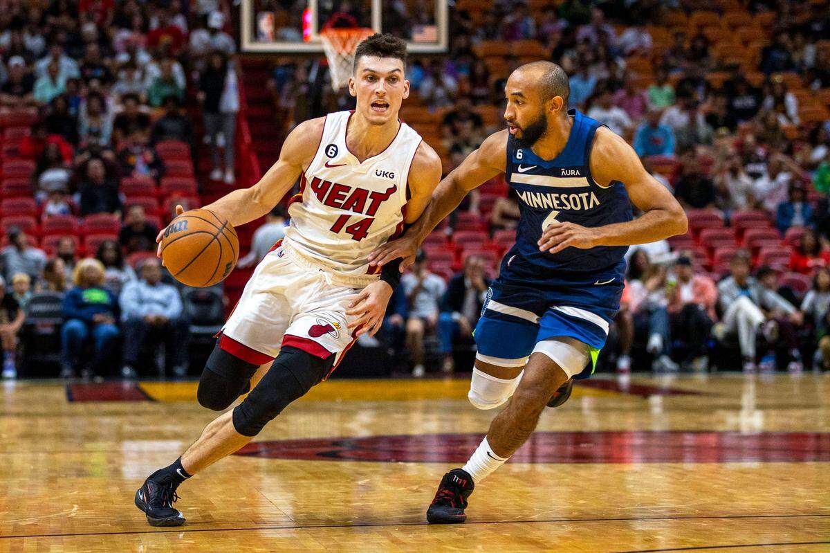 Miami Heat guard Tyler Herro (14) dribbles around Minnesota Timberwolves guard Jordan McLaughlin (6) during the first half of an NBA preseason basketball game at FTX Arena in Miami on October 4, 2022.