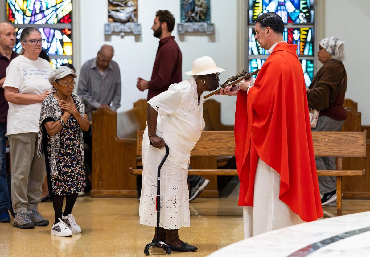 Ameli Geu, 104, kisses a crucifix during a Good Friday service at the Cathedral of St. Mary on Friday, April 18, 2025, in Miami, Fla.