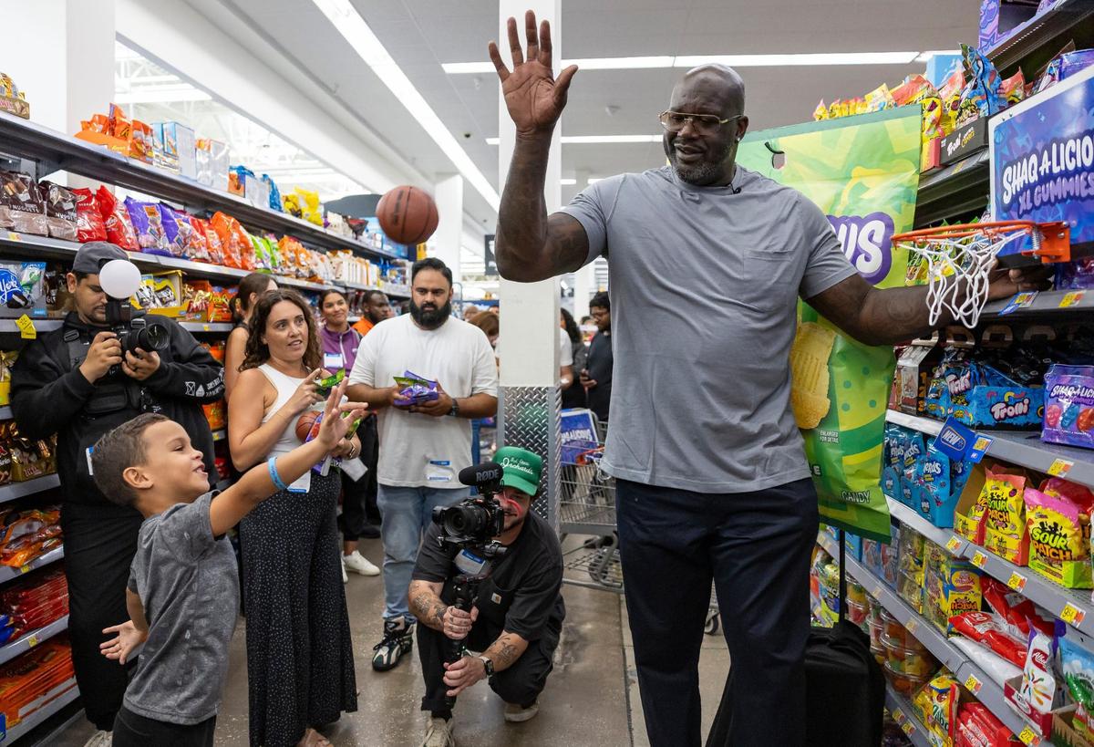 Kai Gonzalez, 5, shoots a small basketball as former Miami Heat player Shaquille O’Neal swats it away during the launch event of his Shaq-a-licious gummies at a Walmart on Monday, Aug. 12, 2024, in Doral, Fla. To promote the candy, O’Neal attended the event while giving free bags of gummies to shoppers.