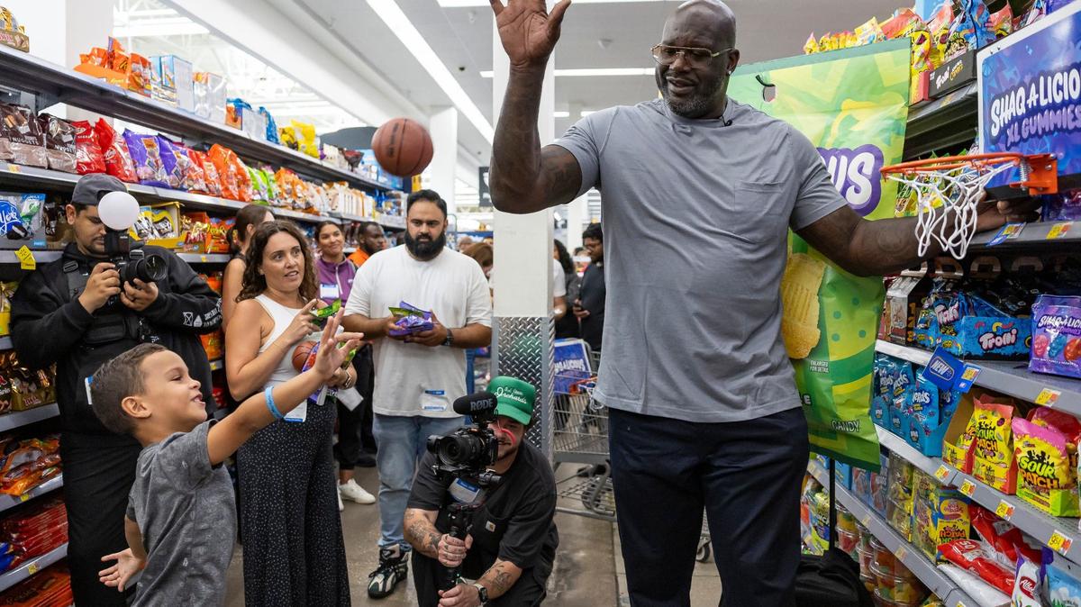 Kai Gonzalez, 5, shoots a small basketball as former Miami Heat player Shaquille O’Neal swats it away during the launch event of his Shaq-a-licious gummies at a Walmart on Monday, Aug. 12, 2024, in Doral, Fla. To promote the candy, O’Neal attended the event while giving free bags of gummies to shoppers.