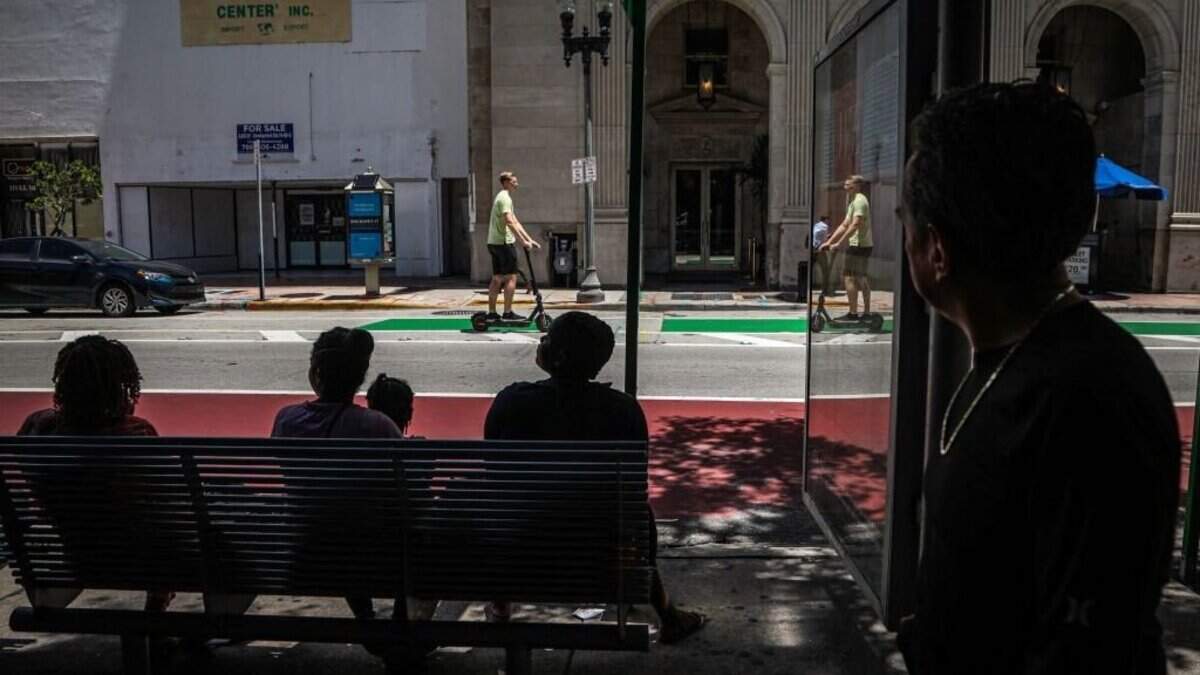 People wait in the shade at a bus stop during a heatwave in Miami, Florida, on June 26, 2023. (Photo by Giorgio Viera / AFP) (Photo by GIORGIO VIERA/AFP via Getty Images)
