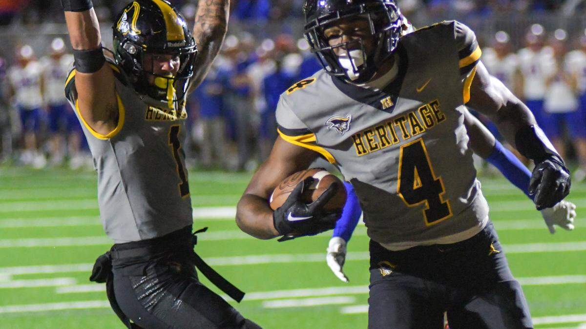 American Heritage wide receiver Brandon Innis (1) and running back Mark Fletcher (4) celebrate after Fletcher’s first-half touchdown in a Class 2M state semifinal game against Jacksonville Bolles on Friday, Dec. 2, 2022, at American Heritage School in Plantation, Florida.