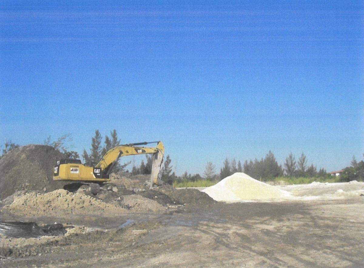 An April photograph shows a contractor working on property owned by Doral 10 LLC, a company managed by the daughter of the late developer Lowell Dunn.