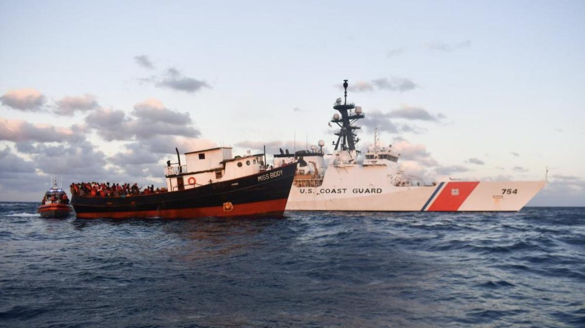 A cargo boat that carried more than 300 people from Haiti floats next to a U.S. Coast Guard cutter offshore eastern Cuba Wednesday, Feb. 15, 2023.