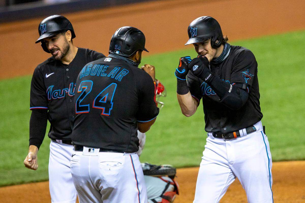Miami Marlins third baseman Brian Anderson (14) reacts after hitting a three run homerun with outfielder Matt Joyce (7) and first baseman Jesus Aguilar (24) at home plate during the fourth inning of a Major League Baseball game against the Philadelphia Phillies at Marlins Park in Miami, Florida on Saturday, September 12, 2020.