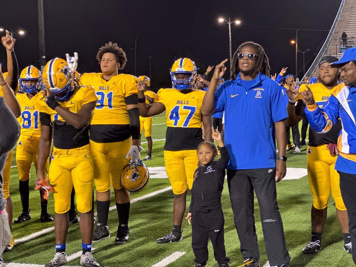 Miami Northwestern football coach Teddy Bridgewater (right) sings the school’s alma mater with his players after the Bulls beat Columbus on Thursday night at Traz Powell Stadium in Miami, Fla.