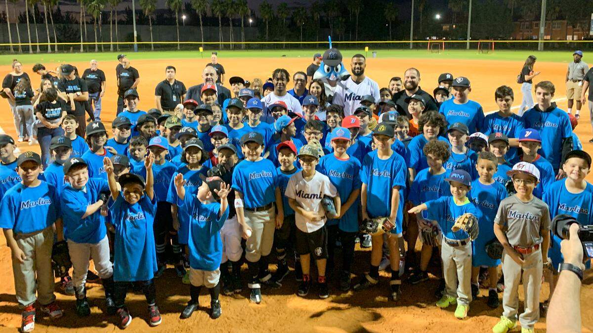 Miami Marlins pitcher Sandy Alcantara and infielder Jean Segura pose with about 100 kids at Doral Meadow Park before taking part in a field day on Tuesday, Feb. 7, 2023.