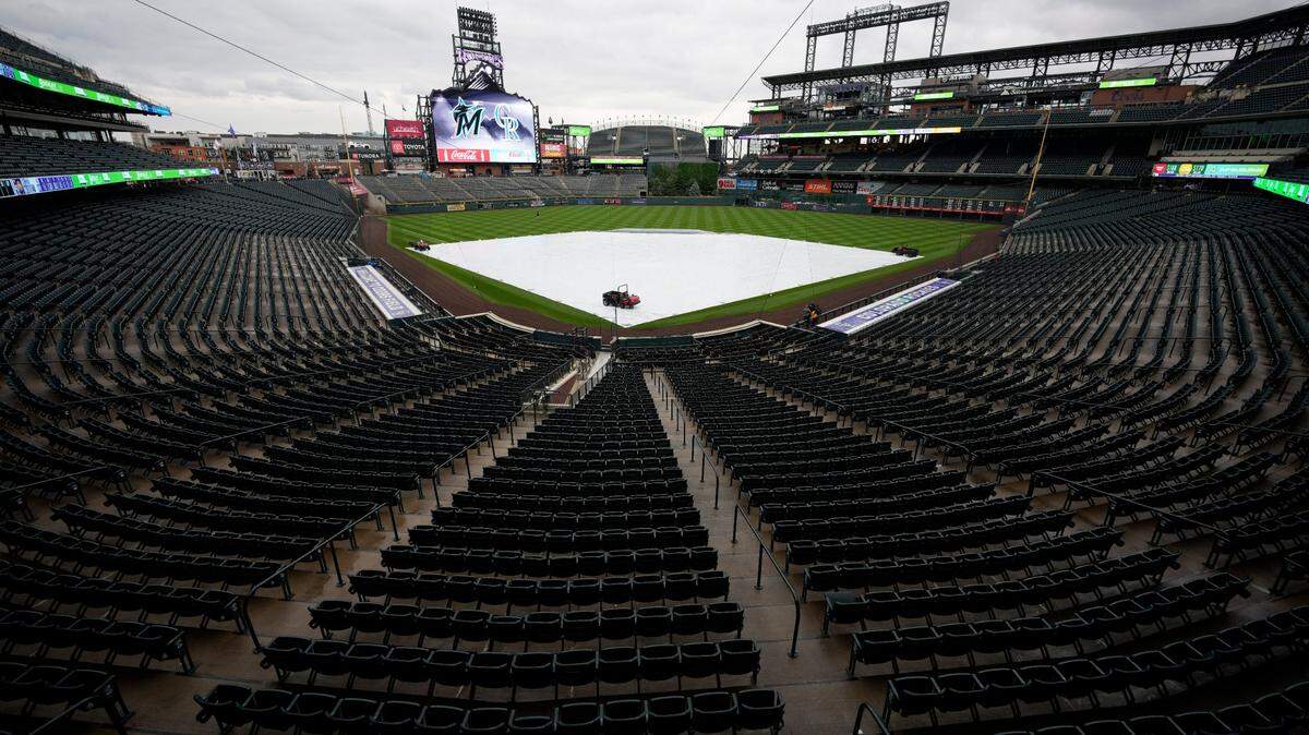 A tarpulin covers the diamond of Coors Field after a baseball game between the Miami Marlins and Colorado Rockies was postponed by stormy weather Tuesday, May 31, 2022, in Denver. The game will be made up as part of a doubleheader on Wednesday, June 1. (AP Photo/David Zalubowski)
