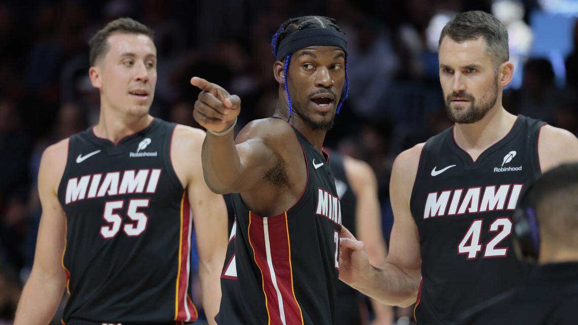 Miami Heat forward Jimmy Butler (22) speaks with teammates Kevin Love (42) and forward Duncan Robinson (55) on the court during the game against the Los Angeles Lakers in the first half of their NBA game at Kaseya Center in Miami on December 4, 2024.