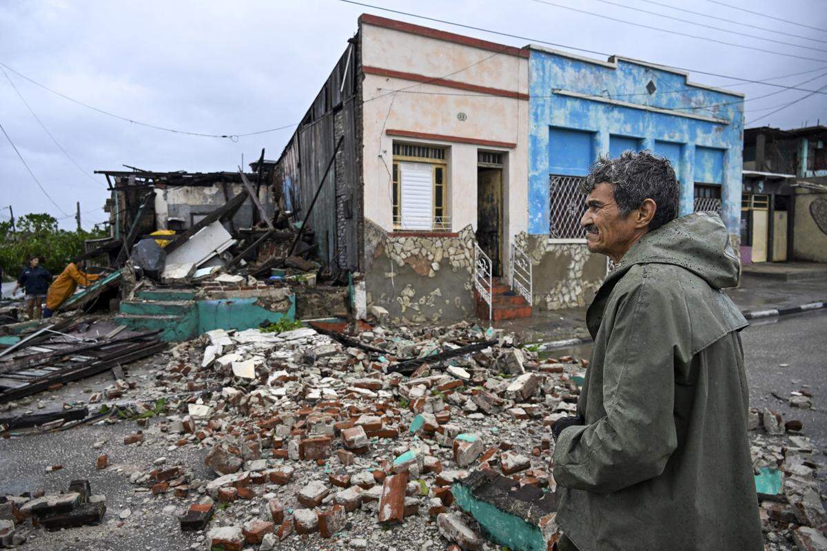 A man looks at houses destroyed by Hurricane Melissa in a neighborhood of Santiago de Cuba on October 29, 2025. A powerful Hurricane Melissa made landfall in eastern Cuba on Wednesday, causing damage and flooding to homes and streets in Santiago de Cuba province, an AFP team on the ground reported. 