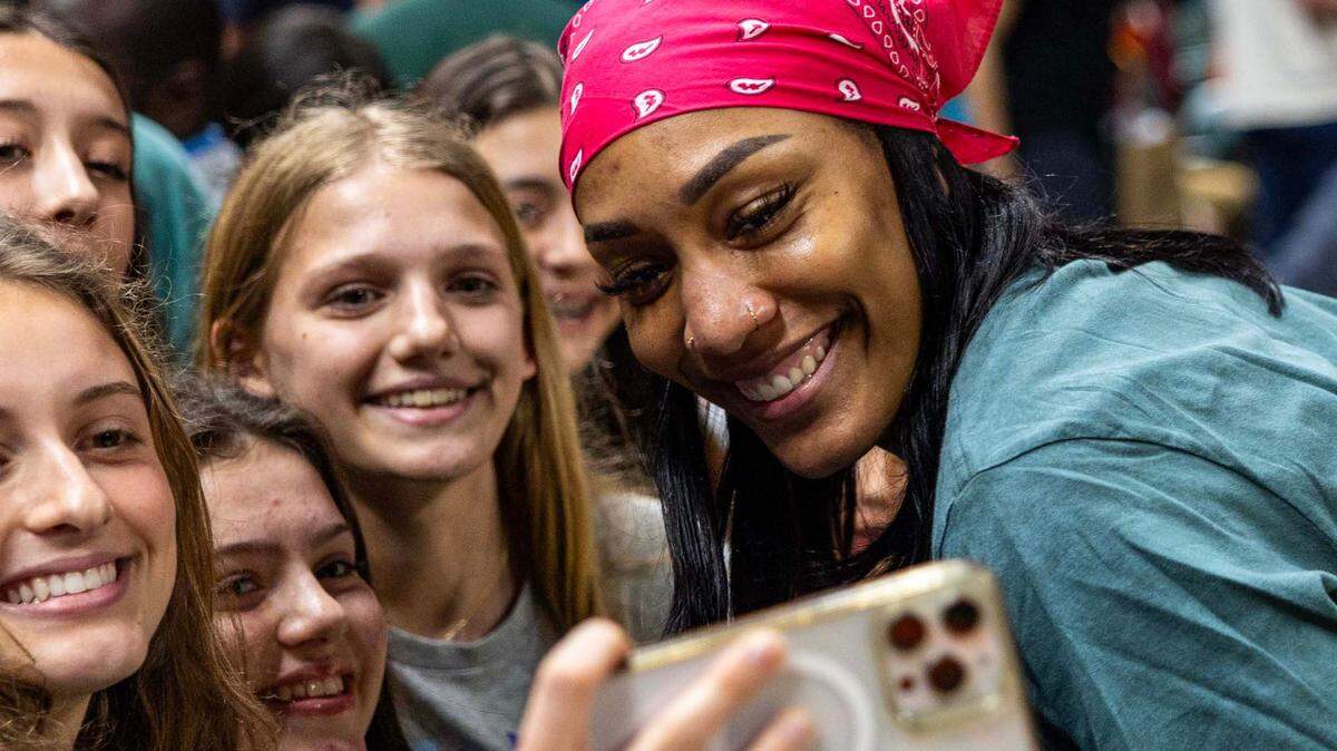 WNBA player A’ja Wilson takes a photo with fans after the second half of an NCAA women’s basketball game between the Miami Hurricanes and the North Carolina Tar Heels at the Watsco Center on Sunday, Dec. 29, 2024, in Coral Gables, Fla.