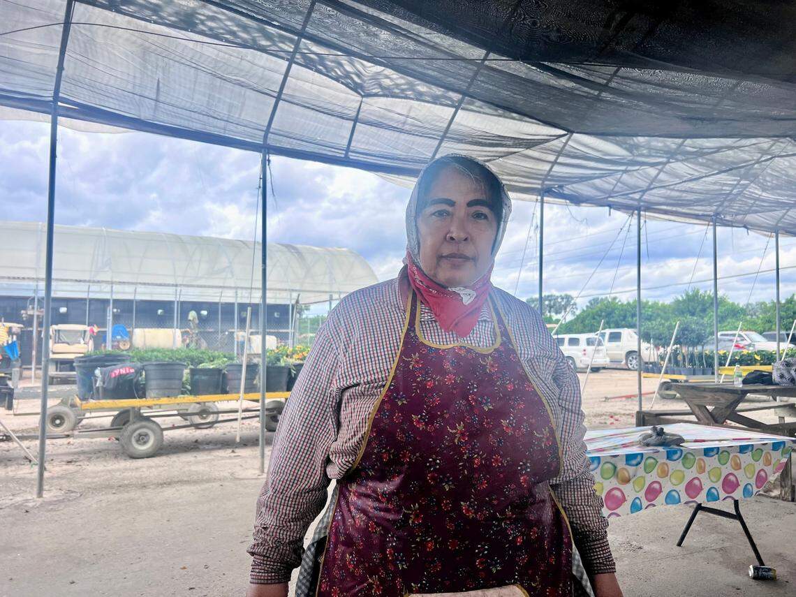 A worker, whose name we are not using to protect her privacy, poses for a photo at the plant nursery before clocking back in to work after lunch.