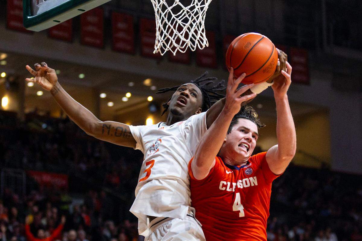 Miami Hurricanes guard Christian Watson (4) blocks a shot by University of Clemson forward Ian Schieffelin (4) during the second half of an NCAA basketball game at the Watsco Center in Coral Gables, Florida, on Wednesday, January 3, 2024.