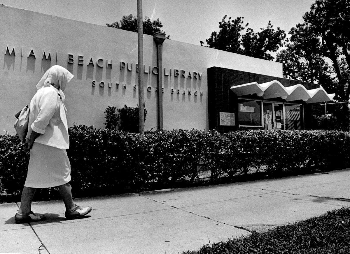 An woman walks past the South Shore Branch of the Miami Beach Public Library.