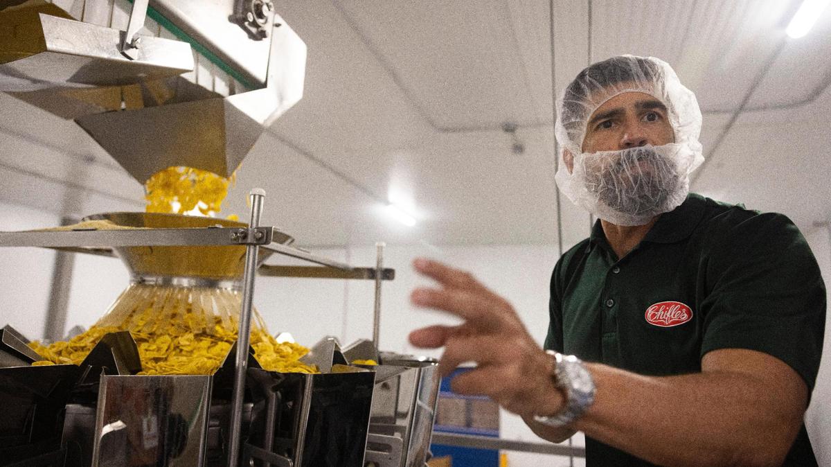 Tony Rivas, presidente ejecutivo de Chifles, mostrando cómo se ponen los chips de plátano en bolsas en la planta de North Miami, el martes 5 de septiembre de 2023.